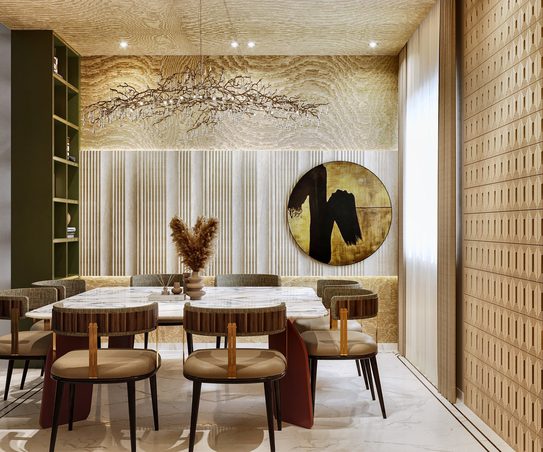 Round marble tables and curved chairs under a textured gold ceiling, with a gold disc artwork on a fluted wall and an olive-green shelving run to one side.