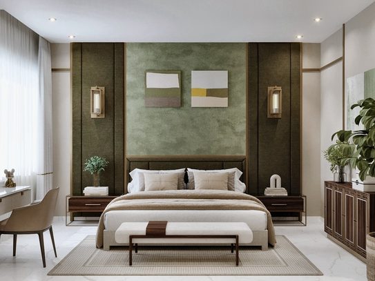A low bed against a deep olive-green upholstered wall, between two brass wall lights, with two framed abstracts above.