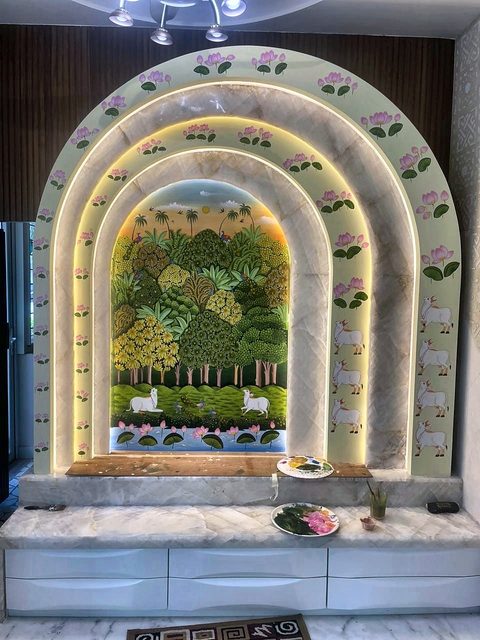 The same arch finished — hand-painted foliage over the whole surface, a green panel behind, cove light around the inner edge, on a stone platform.