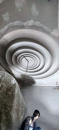 A spiral plaster rosette formed into a ceiling, seen from below.